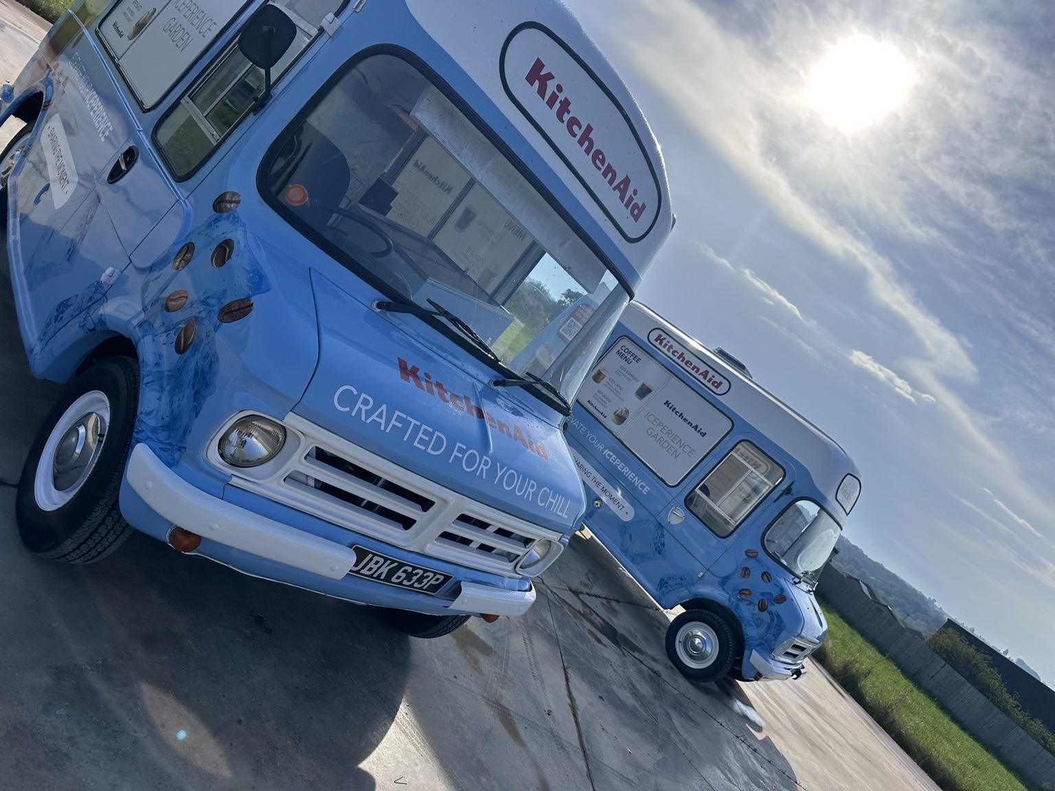 Low-angle photograph of two wrapped Bedford CF vans